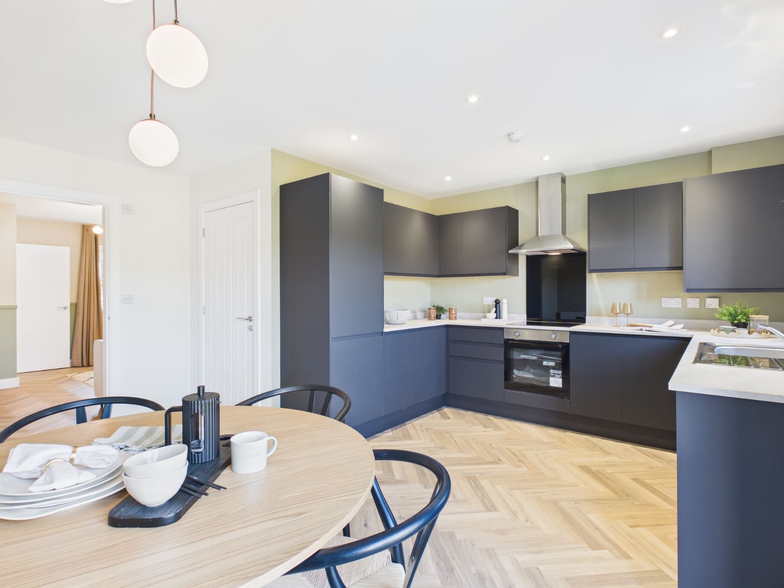 Show home kitchen with dark cabinetry and dining table